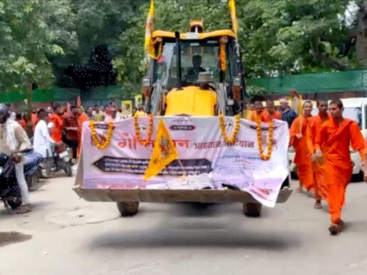 गाय को ‘राष्ट्रमाता’ घोषित करने की मांग, वाराणसी में संतों ने बुलडोजर के साथ डीएम कार्यालय का किया घेराव